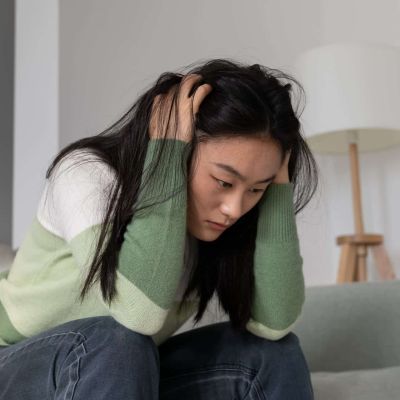 anxious-worried-asian-millennial-girl-holding-head-2023-11-27-05-27-29-utc (1)